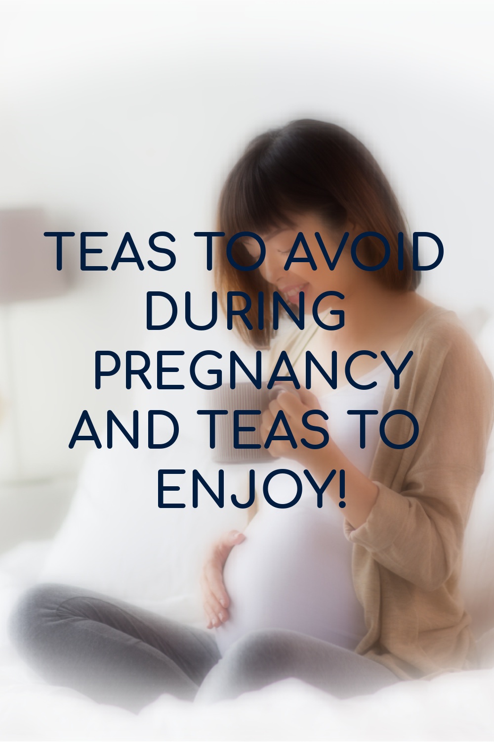 pregnant woman sitting on bed with a cup of tea in hand